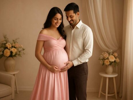 Pregnant woman holding her belly during indoor maternity shoot in Gurgaon